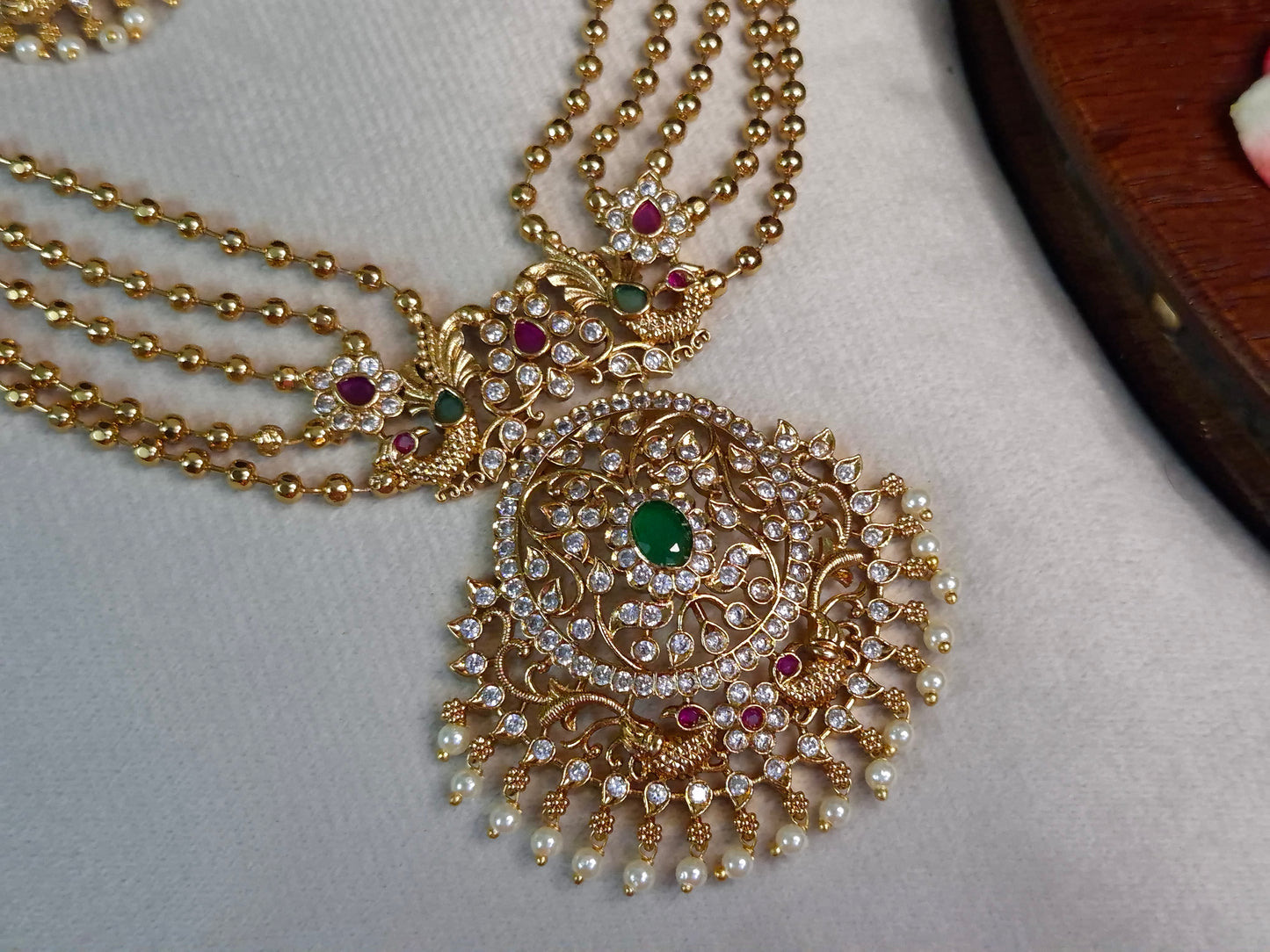 Bridal Peacock Bahubali Necklace Set — Antique Gold 5-Layer Ball Chain with Grand AD & Emerald Pendant and Chandbali Earrings